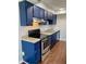 Kitchen with bright blue cabinetry and stainless steel appliances at 1150 Canterbury Ct # Apt D, Indianapolis, IN 46260