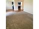 Spacious carpeted living room with blue-toned kitchen in the background at 1150 Canterbury Ct # Apt D, Indianapolis, IN 46260