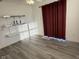 Bedroom featuring gray wood flooring, floating shelves, and red curtains at 11523 Coastal Way, Indianapolis, IN 46229