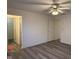 Bedroom featuring gray wood flooring, walk-in closet, and a ceiling fan with a light fixture at 11523 Coastal Way, Indianapolis, IN 46229