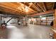 Spacious unfinished basement featuring exposed wood beams, shelving, and utilities at 117 S Spencer Ave, Indianapolis, IN 46219