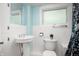 Bright bathroom with white wainscoting, a pedestal sink, toilet, and a window for natural light at 117 S Spencer Ave, Indianapolis, IN 46219