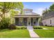 Charming blue two-story home with a cozy front porch and landscaped front yard at 117 S Spencer Ave, Indianapolis, IN 46219