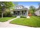 Inviting blue two-story home with manicured lawn, sidewalk, and covered front porch at 117 S Spencer Ave, Indianapolis, IN 46219