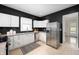 Updated kitchen with stainless steel appliances, white cabinets, and dark accent walls at 117 S Spencer Ave, Indianapolis, IN 46219