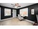 Spacious living room with dark accent wall, ceiling fan and a view of the backyard at 117 S Spencer Ave, Indianapolis, IN 46219