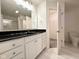 Modern bathroom featuring a black countertop, white cabinets, a large mirror, and a shower for convenience at 11711 Whisper Cove Dr, Fishers, IN 46037