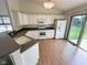 Well-lit kitchen with white cabinets, gray countertops, and a sliding glass door to the backyard at 11711 Whisper Cove Dr, Fishers, IN 46037