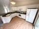 Modern kitchen with white cabinetry, gray countertops, and hardwood floors at 11711 Whisper Cove Dr, Fishers, IN 46037