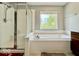This bathroom features a separate shower and soaking tub beneath a sunlit window at 12044 Bird Key Blvd, Fishers, IN 46037