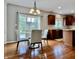 A sunlit dining area with hardwood floors, a modern chandelier, and views of the backyard at 12044 Bird Key Blvd, Fishers, IN 46037