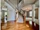 A grand foyer with hardwood floors and a staircase featuring white railings and wood trim at 12044 Bird Key Blvd, Fishers, IN 46037