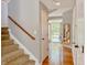 Hallway and staircase featuring wood floors, leading to the front door and upper level at 12044 Bird Key Blvd, Fishers, IN 46037