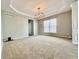A bright living room with neutral carpet, trey ceiling, modern lighting, and ample space for decor at 12044 Bird Key Blvd, Fishers, IN 46037