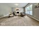 Cozy living room featuring a fireplace, large windows, neutral carpet and paint, plus comfortable seating at 12044 Bird Key Blvd, Fishers, IN 46037