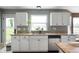 Bright kitchen area with white cabinets, stainless steel dishwasher, and granite countertops with a large window at 12331 Chiseled Stone Dr, Fishers, IN 46037