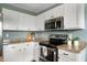 Close-up of modern kitchen featuring stainless steel appliances, granite countertops, and white cabinetry at 12331 Chiseled Stone Dr, Fishers, IN 46037