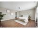 Spacious main bedroom with hardwood floors, a large bed, and views into the main bathroom at 12331 Chiseled Stone Dr, Fishers, IN 46037