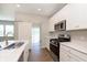 Modern kitchen featuring stainless steel appliances, white cabinets, and a sliding barn door at 1237 Langham St, Avon, IN 46123