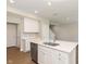 Bright kitchen features an island with a stainless steel sink and white cabinets at 1237 Langham St, Avon, IN 46123