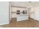 Open kitchen with stainless steel appliances, island with sink, and white cabinetry at 1237 Langham St, Avon, IN 46123