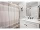 Bright bathroom featuring a vanity with mirror, striped shower curtain, and tiled walls at 1310 Olive St, Indianapolis, IN 46203