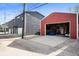 Exterior angle shot of a red, detached garage with an open door, revealing a casual hangout space at 1310 Olive St, Indianapolis, IN 46203
