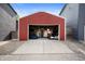 A red, detached garage with an open door, revealing a casual hangout space at 1310 Olive St, Indianapolis, IN 46203