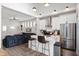 Open-concept kitchen with stainless steel appliances, white cabinets, and a breakfast bar at 1310 Olive St, Indianapolis, IN 46203