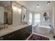This bathroom features a soaking tub, double sink vanity, and ample natural light at 13244 Snow Owl Dr, Carmel, IN 46033