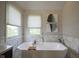 This bathroom features a soaking tub, marble walls, and large windows at 13244 Snow Owl Dr, Carmel, IN 46033