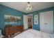 This bedroom features blue walls, wood floors, and a large painting at 13244 Snow Owl Dr, Carmel, IN 46033