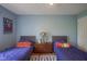 Bright bedroom featuring twin beds, blue walls, and a shared nightstand at 13244 Snow Owl Dr, Carmel, IN 46033