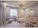 Bright bedroom featuring charming decor, a chandelier, and a view of the front yard at 13244 Snow Owl Dr, Carmel, IN 46033