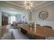 Bright dining room with wood table, stylish chandelier and view into the adjacent living room at 13244 Snow Owl Dr, Carmel, IN 46033