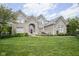 Attractive brick home featuring a manicured lawn and a striking red front door at 13244 Snow Owl Dr, Carmel, IN 46033