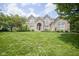 Stunning brick home featuring a large front yard, red door, and mature trees at 13244 Snow Owl Dr, Carmel, IN 46033