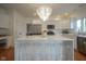 Bright kitchen featuring a large island with seating, stainless steel appliances, and a modern chandelier at 13244 Snow Owl Dr, Carmel, IN 46033