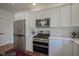 A view of a bright kitchen featuring modern appliances, hexagonal backsplash, and ample cabinet space at 13244 Snow Owl Dr, Carmel, IN 46033