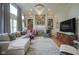 Bright living room featuring comfortable seating, a fireplace, built-in bookshelves, and a modern chandelier at 13244 Snow Owl Dr, Carmel, IN 46033
