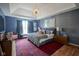 Serene bedroom with blue walls, tray ceiling, and plush bedding with decorative pillows at 13244 Snow Owl Dr, Carmel, IN 46033