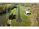 High-angle view of the airstrip, revealing houses, a pond, and other structures across the property at 1340 Apache Trl, Martinsville, IN 46151