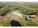 Aerial perspective showcasing a home and large, white warehouse building surrounded by trees and a large pond at 1340 Apache Trl, Martinsville, IN 46151