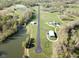 Expansive aerial view of a private airstrip, complete with a pond, green spaces, and residential buildings at 1340 Apache Trl, Martinsville, IN 46151