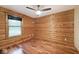 Bedroom showcasing wood paneled walls, wood floors, ceiling fan and one window at 1340 Apache Trl, Martinsville, IN 46151