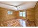 Bedroom featuring wood paneled walls, wood floors, ceiling fan and multiple windows at 1340 Apache Trl, Martinsville, IN 46151