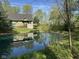 Exterior view of the home showcasing a pond, lush lawn, and beautiful landscaping at 1340 Apache Trl, Martinsville, IN 46151