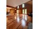 Spacious living room featuring hardwood floors, wood paneling, and plenty of natural light from large windows at 1340 Apache Trl, Martinsville, IN 46151
