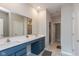 Bathroom featuring double sink vanity with blue cabinetry, large mirrors, and marble floors at 1483 Paper Birch Dr, Sheridan, IN 46069