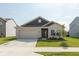 Charming one-story home featuring a gray brick facade, a two-car garage, and a well-manicured front lawn at 1483 Paper Birch Dr, Sheridan, IN 46069
